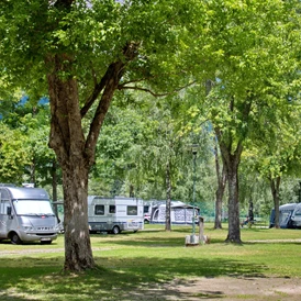 Wohnmobilstellplatz: 220 Stellplätze im Schatten, Halbschatten oder Sonne je nach Bedarf und Jahreszeit von 70m2 - 120m2. Wunderbare Aussicht auf die Berg in der Umgebung. - Camping am Waldbad