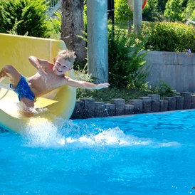 Wohnmobilstellplatz: Die Wasserrutsche - das Highlight für unsere Kinder im Erlebnisbecken. Im Sportbecken kann in Ruhe geschwommen werden. - Camping am Waldbad