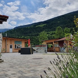 Wohnmobilstellplatz: Eingangsbereich, Treffpunkt Rafting, Outdoor Bar im Hintergrund - Adventurepark Osttirol
