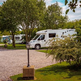 Wohnmobilstellplatz: Hard standing pitches with grass for awning. - Long Acres Touring Park