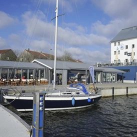 Wohnmobilstellplatz: Blick auf Eiscafé und maritimen Shop - Stellplatz am Schleswiger Stadthafen