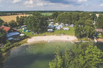 Wohnmobilstellplatz: Luftbild von Strand, Campingwiese und Restaurant mit Biergarten vom blauen See aus gesehen. - Campingplatz Blauer See / Reisemobilstellplatz am Blauen See